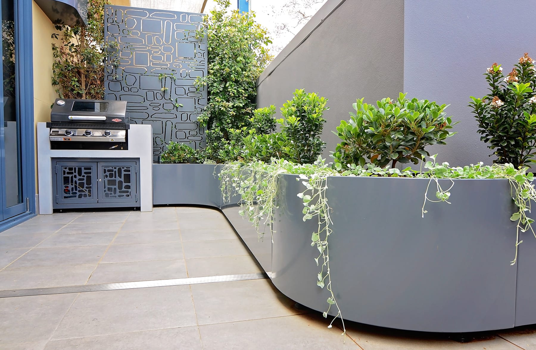 Aluminium planters in a paved courtyard