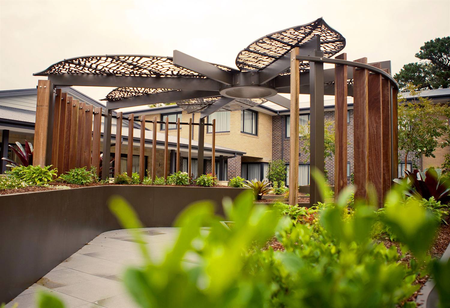 Custom pergola with laser-cut canopy and Corten planter wall by POBOX